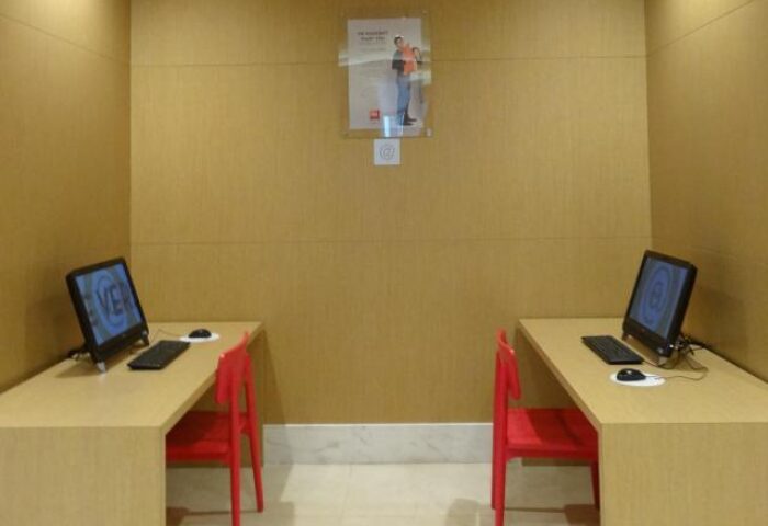 Ibis Hong Kong Central & Sheung Wan Hotel's business center. Two desks with computers, chairs, and internet access for guests' convenience.