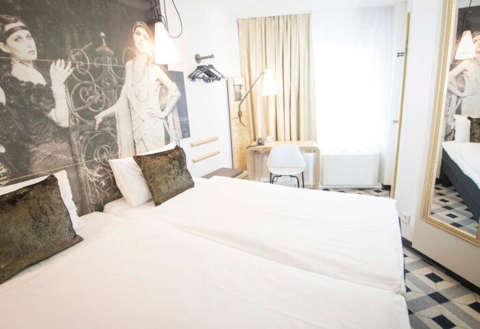 Ibis Hotel Koeln Centrum room. Gay-friendly hotel with twin beds, desk, and vintage-style decor. A comfortable stay in Cologne, Germany.