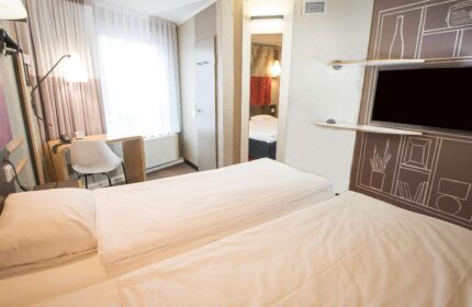 Ibis Hotel Koeln Centrum room. Gay-friendly hotel with twin beds, desk, and TV. Modern design for gay travelers in Cologne, Germany.
