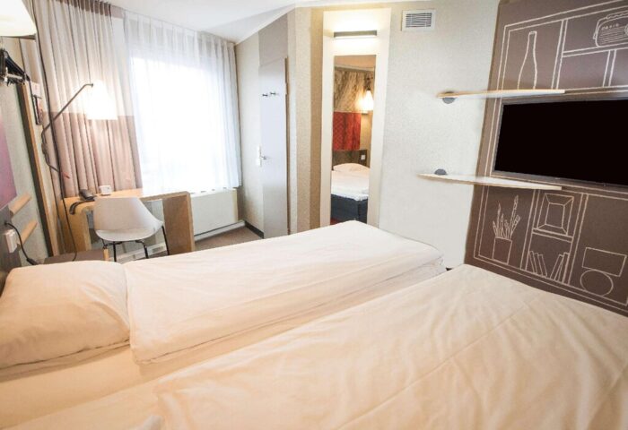 Ibis Hotel Koeln Centrum room. Gay-friendly hotel with twin beds, desk, and TV. Modern design for gay travelers in Cologne, Germany.