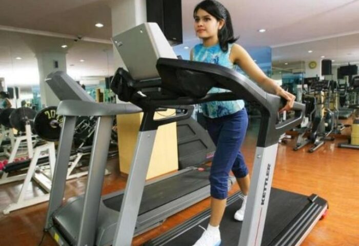Ibis Jakarta Tamarin Hotel gym: Woman on treadmill. Fitness center at this gay-friendly hotel in Jakarta, Indonesia. Weights and machines visible.