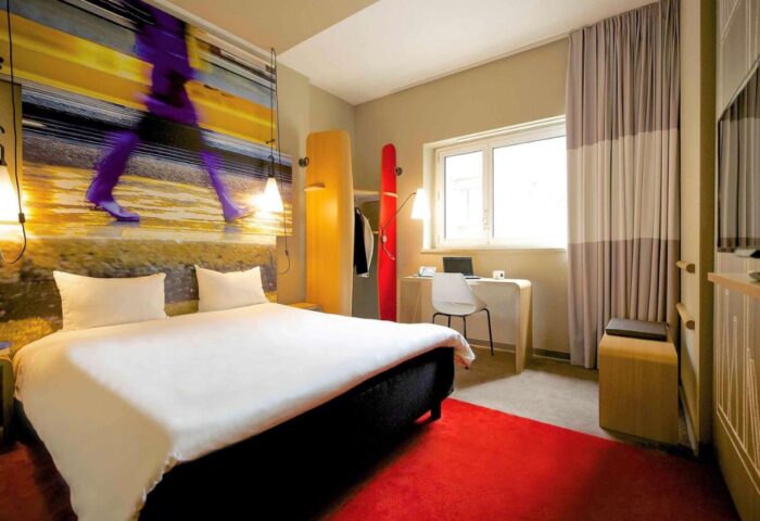 Ibis Milano Centro Hotel room. Modern design, bright colors, desk, and bed. Gay-friendly hotel in Milan, Italy, for gay men travelers.