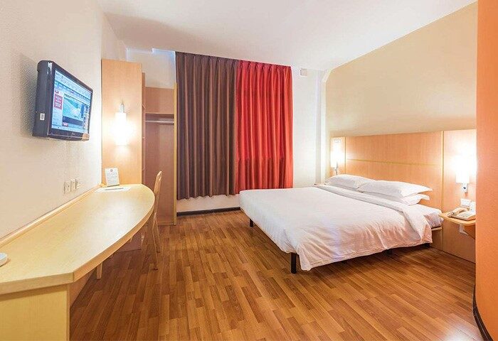 Ibis Shanghai Xujiahui Hotel room. Gay-friendly hotel offers a comfortable stay with a bed, desk, TV, & modern amenities. Shanghai travel.