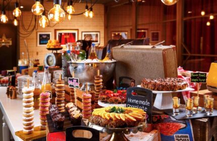 Ibis Styles London Southwark Hotel's breakfast buffet. Gay-friendly hotel with donuts, cakes, juice, and vintage decor for gay men travelers.