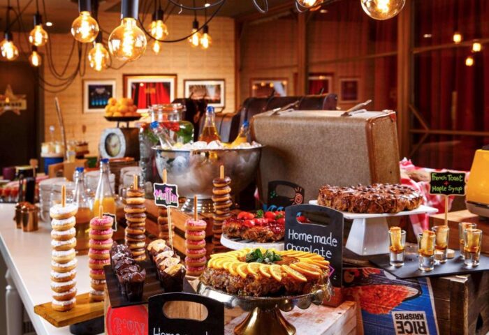 Ibis Styles London Southwark Hotel's breakfast buffet. Gay-friendly hotel with donuts, cakes, juice, and vintage decor for gay men travelers.