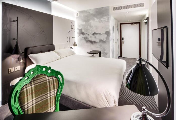 Ibis Styles London Southwark Hotel room. Gay-friendly hotel with double bed, stylish decor, green chair, and modern amenities. Ideal for gay travel.