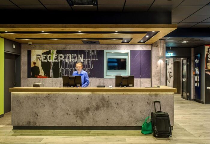 Ibis budget Berlin Kurfurstendamm hotel reception area. Modern design, front desk, staff, luggage. Gay-friendly hotel in Berlin.