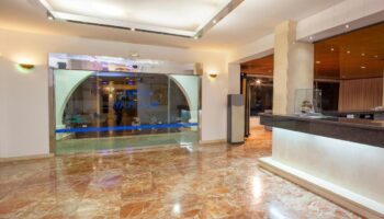 Ibiza Playa gay-friendly hotel entrance. Reception area with marble floors and glass doors. Welcoming space for gay travelers in Ibiza.