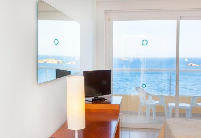 Ibiza Playa gay-friendly hotel room. Balcony view of the sea. Perfect for gay travel. Modern interior, relaxing vacation.