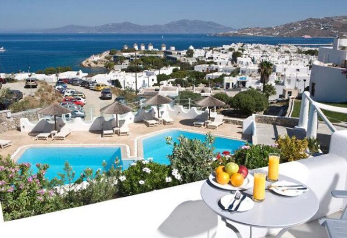 Ilio Maris gay-friendly hotel view. Mykonos town, pool, windmills, sea. Gay travel destination. Balcony with breakfast.
