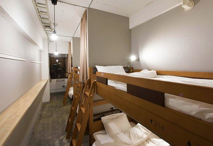 Imano Tokyo Hostel gay-friendly dorm. Bunk beds with ladders, white linens, and privacy curtains. Clean, modern design for gay travelers in Tokyo.