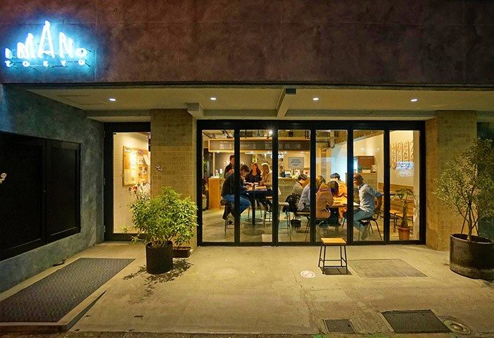 Imano Tokyo Hostel exterior. Gay-friendly hotel in Tokyo, Japan. People dining inside. A welcoming space for gay travelers.