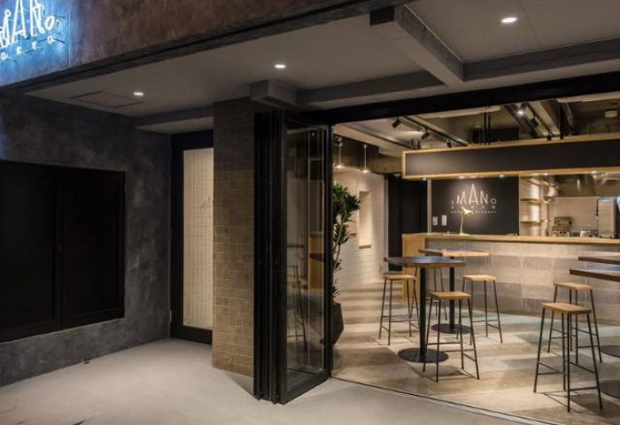 Imano Tokyo Hostel's entrance. This gay-friendly hotel features a stylish bar area with high stools, perfect for socializing in Tokyo, Japan.
