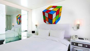 Imperial Palace Boutique Hotel room. Gay-friendly hotel with a Rubik's cube decoration. Modern design, white bedding, and mirrored closet.