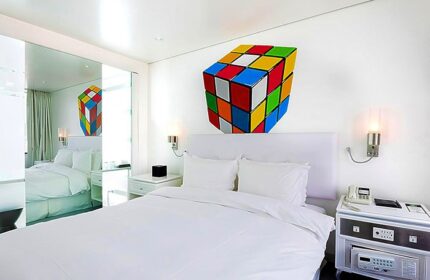 Imperial Palace Boutique Hotel room. Gay-friendly hotel with a Rubik's cube decoration. Modern design, white bedding, and mirrored closet.