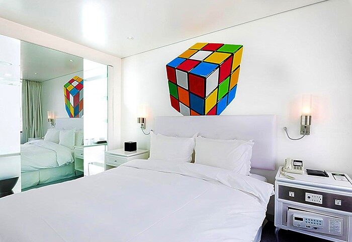 Imperial Palace Boutique Hotel room. Gay-friendly hotel with a Rubik's cube decoration. Modern design, white bedding, and mirrored closet.