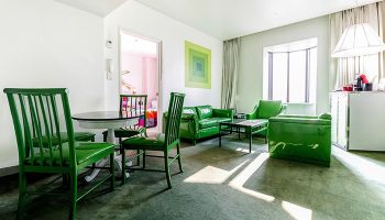 Imperial Palace Boutique Hotel's gay-friendly room. Green furniture: chairs, table, sofas. Modern design, comfortable for gay travelers.