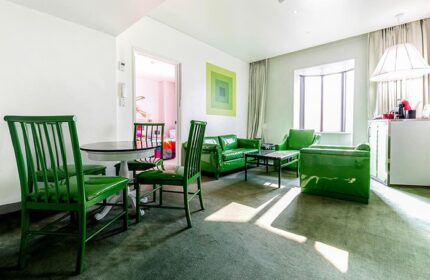 Imperial Palace Boutique Hotel's gay-friendly room. Green furniture: chairs, table, sofas. Modern design, comfortable for gay travelers.