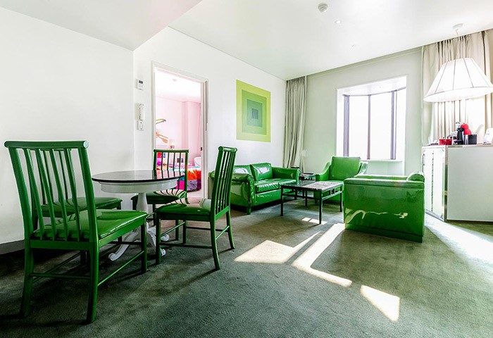 Imperial Palace Boutique Hotel's gay-friendly room. Green furniture: chairs, table, sofas. Modern design, comfortable for gay travelers.