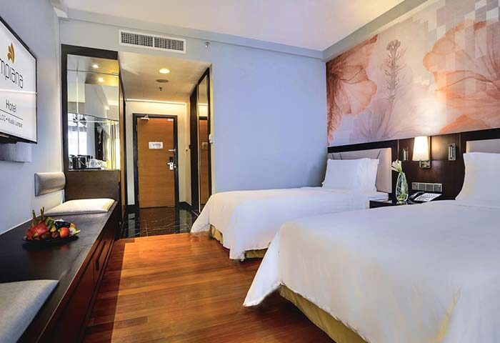 Impiana KLCC Hotel room. Gay-friendly hotel with twin beds, floral wall art, wooden floors, and a TV. Ideal for gay men travelers in Kuala Lumpur.
