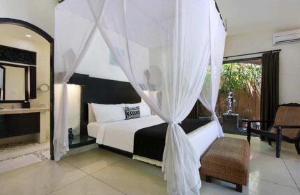 Impiana Private Villas Seminyak bedroom. Gay-friendly hotel with canopy bed, ensuite bathroom, and outdoor garden view. Luxury Seminyak villa.
