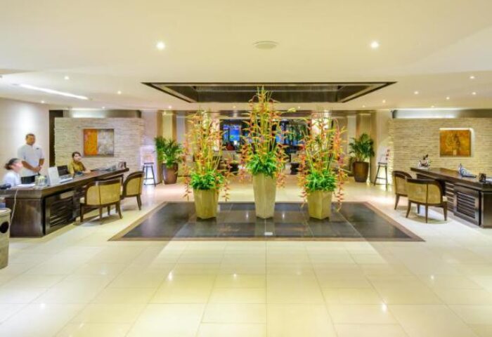 Impiana Resort Patong's lobby, a gay-friendly hotel. Floral arrangements decorate the reception area. A welcoming space for gay travelers.