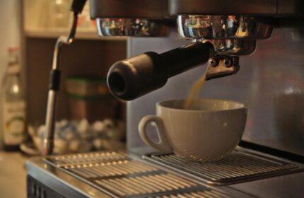 Industriepalast Hostel Berlin: Espresso machine making coffee. Gay-friendly hotel offers amenities for a comfortable stay in Berlin.
