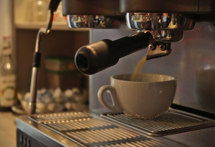 Industriepalast Hostel Berlin: Espresso machine making coffee. Gay-friendly hotel offers amenities for a comfortable stay in Berlin.