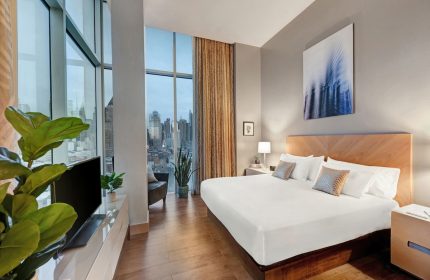 Ink 48 Hotel room with city view. Gay-friendly hotel featuring modern design, king bed, and floor-to-ceiling windows. Upscale lodging for gay travelers.