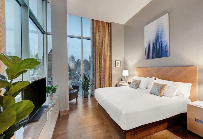 Ink 48 Hotel room with city view. Gay-friendly hotel featuring modern design, king bed, and floor-to-ceiling windows. Upscale lodging for gay travelers.