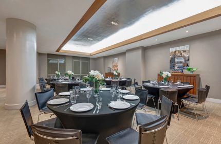 Ink 48 Hotel's event space, a gay-friendly hotel, features round tables with black tablecloths, set for a sophisticated gathering.
