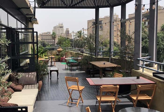 Rooftop view at Inta Hotel, a gay-friendly adults-only hotel in Tel Aviv-Jaffa. Tables, chairs, and city views create a relaxing atmosphere.