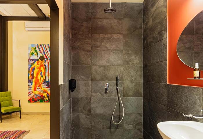 Inta Hotel Tel Aviv Jaffa adults-only bathroom. Modern shower, sink, and art. Gay-friendly hotel for gay men's travel.