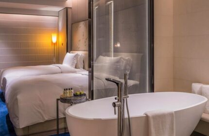 InterContinental Beijing Sanlitun gay-friendly hotel room. Modern bathtub in foreground, twin beds in background. Luxury travel for gay men.