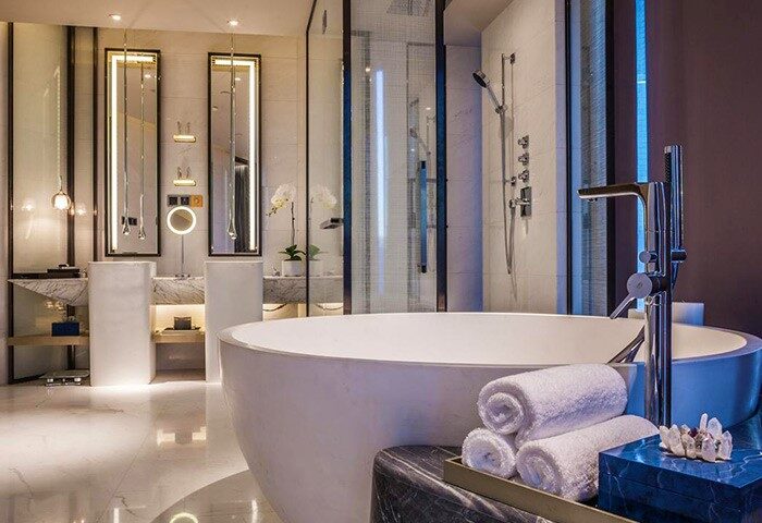 InterContinental Beijing Sanlitun gay-friendly hotel bathroom. Modern design with a large tub, towels, and sleek fixtures. Luxury travel.