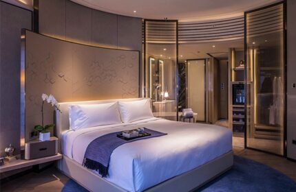 InterContinental Beijing Sanlitun room. Gay-friendly hotel bedroom with king bed, ensuite bathroom, closet, and modern decor. Upscale travel.