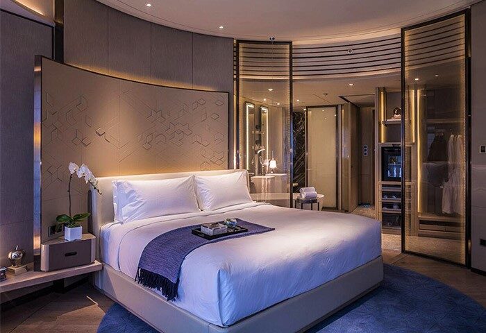 InterContinental Beijing Sanlitun room. Gay-friendly hotel bedroom with king bed, ensuite bathroom, closet, and modern decor. Upscale travel.