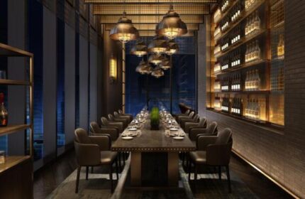 InterContinental Beijing Sanlitun gay-friendly hotel dining room. Long table set for dinner, wine shelves, and modern lighting fixtures.