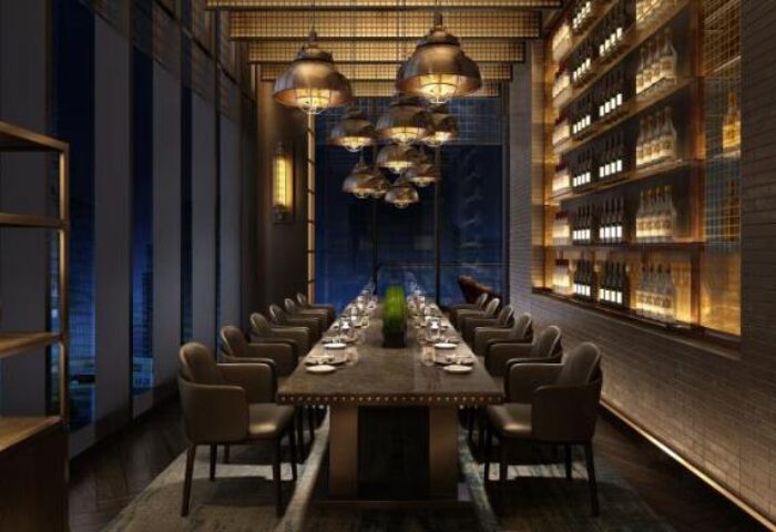 InterContinental Beijing Sanlitun gay-friendly hotel dining room. Long table set for dinner, wine shelves, and modern lighting fixtures.