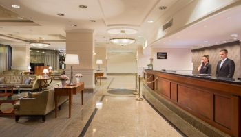 InterContinental Budapest lobby. A gay-friendly, pet-friendly hotel. Reception desk with staff, elegant seating area. Luxury travel.