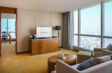 InterContinental Hanoi Landmark72 gay-friendly hotel room. Living area with sofa, TV, and city view. Luxury travel for gay men in Hanoi.