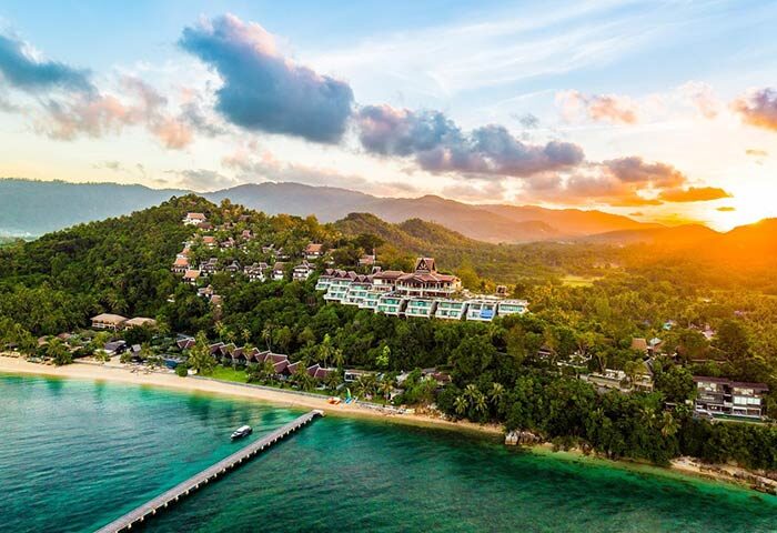 InterContinental Koh Samui Resort, a gay-friendly hotel. Beachfront view of the resort at sunset, with lush greenery and ocean views.