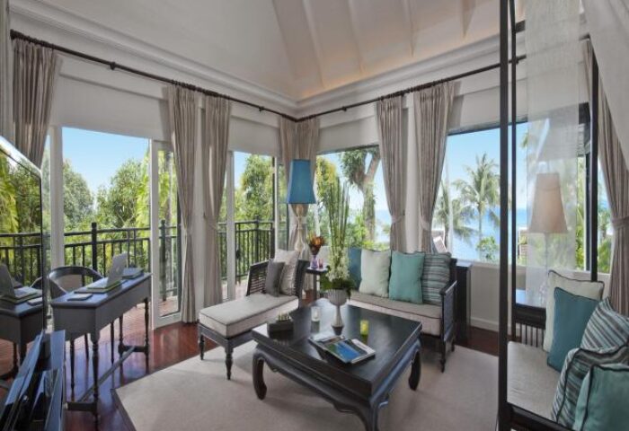 Interior of a gay-friendly InterContinental Koh Samui Resort room. Balcony view with trees and ocean. Luxury travel for gay men.