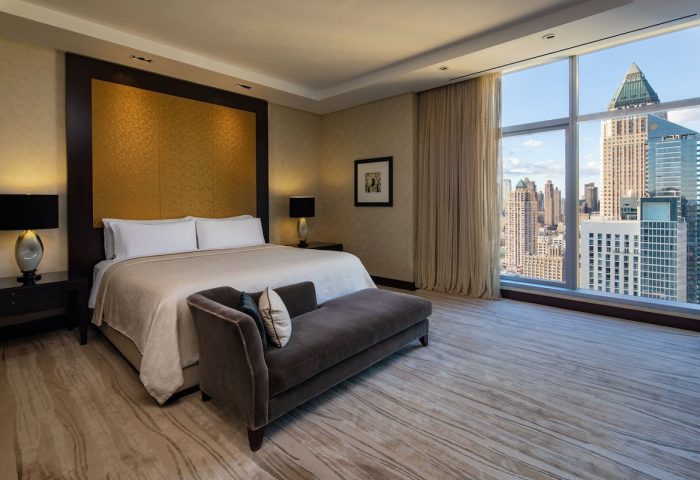 InterContinental New York Times Square gay-friendly hotel room. King bed, chaise lounge, city view. Luxurious gay travel accommodations.