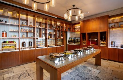 InterContinental New York Times Square gay-friendly hotel breakfast buffet. A long table with food warmers. Shelves with food items in the background.