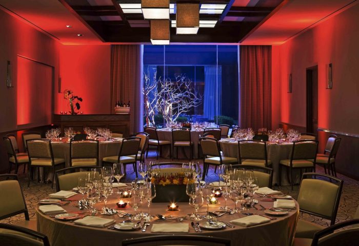 InterContinental New York Times Square gay-friendly hotel ballroom. Round tables set for a special event. Red and blue lighting.