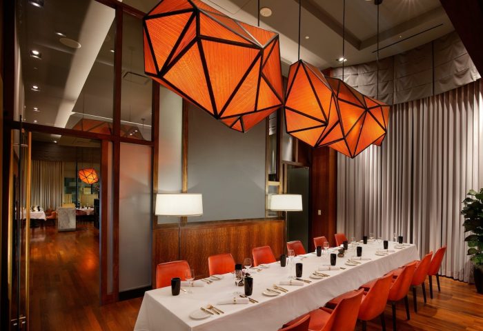 InterContinental San Francisco gay-friendly hotel dining room. Long table set for dinner, orange geometric light fixtures.