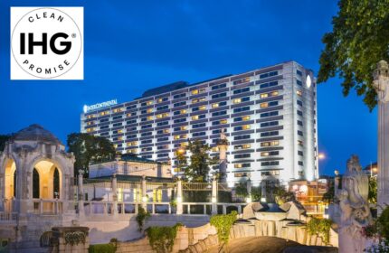 InterContinental Wien, a gay-friendly hotel. Exterior view at dusk with IHG Clean Promise logo. Vienna travel for gay men.