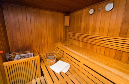 Sauna at Gay-Friendly InterContinental Wien Hotel. Wooden interior with benches, bucket, and towel. Relax and unwind in Vienna's gay scene.