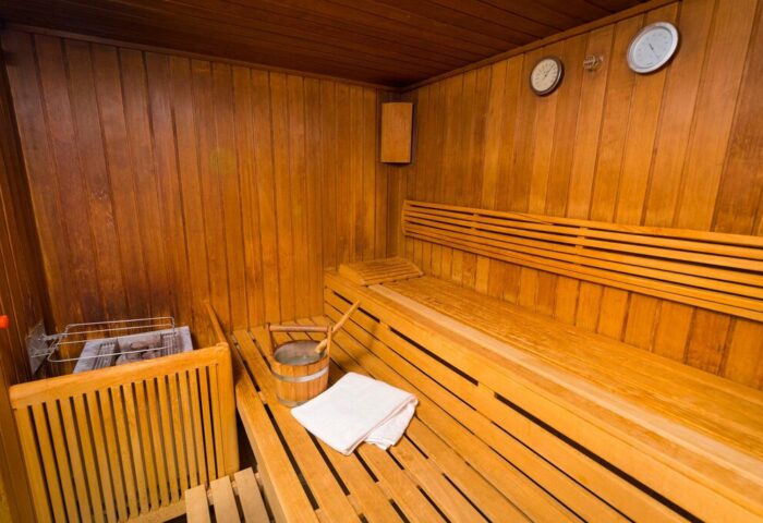 Sauna at Gay-Friendly InterContinental Wien Hotel. Wooden interior with benches, bucket, and towel. Relax and unwind in Vienna's gay scene.